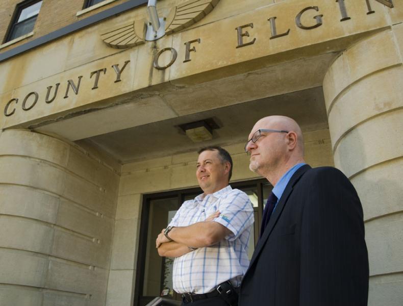two men standing in front of County of Elgin building 